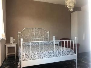 een slaapkamer met een wit bed en een kroonluchter bij Al chiaro di luna (009029-LT-0962) in Finale Ligure