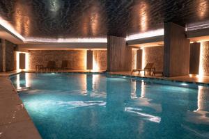 a large swimming pool in a building with lights at Spacious Apt With Balcony- Tranquil City Haven in Istanbul
