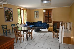 a living room with a blue couch and tables and chairs at La Villa du Papetier in Boussières