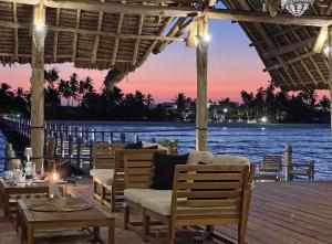a restaurant with a view of the water at sunset at Pongwe Bay Resort in Pongwe