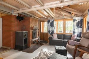 a living room with a couch and a fireplace at Cottage with Hot tub and Sauna in Uurainen