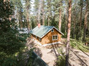 a small wooden cabin in the middle of a forest at Cottage with Hot tub and Sauna in Uurainen