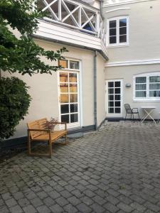 a bench sitting in front of a house at Nyrenoveret charmerende lejlighed i Odense C! in Odense
