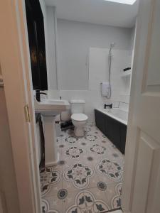 uma casa de banho com um WC, um lavatório e uma banheira em Modern 4 Bedroom Townhouse in City Centre em Dublin