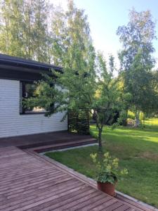 Cosy and tidy house in Lapland , Keminmaa في Keminmaa: منزل به سطح خشبي وساحة