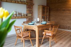 einem Holztisch mit 2 Stühlen und einem Tisch mit Brille in der Unterkunft Zubrzyckie Pokoje in Zubrzyca Dolna