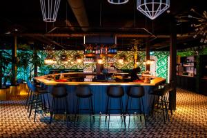 un bar en un restaurante con taburetes alrededor en ibis Styles Amsterdam Airport, en Schiphol