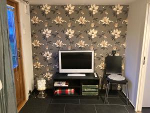 Pokój z monitorem komputerowym na ścianie z kwiatami w obiekcie Annexet w mieście Hässleholm