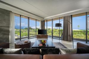 a living room with a couch and a tv at The Sense Apartment - Modern, Near My An Beach in Da Nang