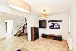 una gran sala de estar con TV y escaleras en Casa Albert 2 en Iaşi