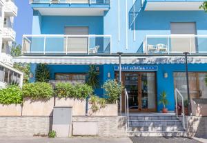 un edificio blu con scale e piante di fronte di Hotel Cristina a Rimini