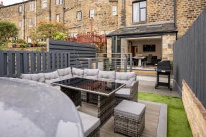 a patio with a couch and a table in a yard at Billie Island apartments in Slaithwaite