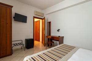 a bedroom with a bed and a desk and a television at A Casa Dei Gonzaga in Mantova