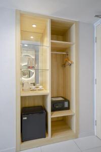 a kitchen with wooden shelves and a microwave at Solaris Hotel Kuta in Kuta