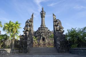 a gate to a temple with a monument in the background at Solaris Hotel Kuta in Kuta