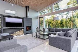 sala de estar con sofá y chimenea en Villa Padel - Premium Lakeside Residence & Grounds en Lohja