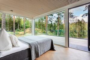 Villa Padel - Premium Lakeside Residence & Grounds في Lohja: غرفة نوم بسرير مقابل نافذة كبيرة