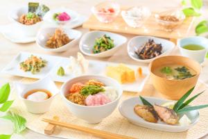 a table topped with bowls of food and chopsticks at Ooedo Onsen Monogatari Premium Ikaho in Shibukawa