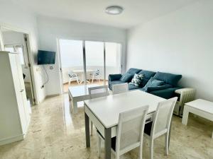 sala de estar con sofá, mesa y sillas en Apartamento SeaView en Sitio de Calahonda