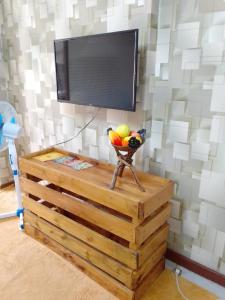einen TV an einer Wand mit einem Tisch und einer Obstschale in der Unterkunft Tsavo 90 degrees smart view in Nairobi
