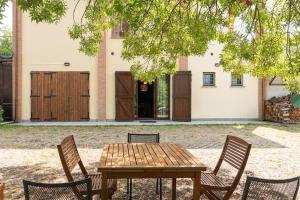 a wooden table and chairs in front of a house at CASOLARA: ospitalità su misura in Castello di Serravalle