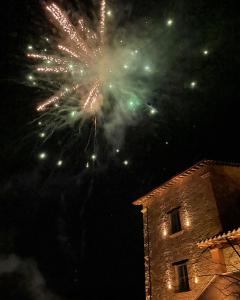 un espectáculo de fuegos artificiales en el cielo sobre un edificio en Agriturismo Colle Casini Cortesi, en Caldarola