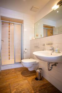 La salle de bains est pourvue d'un lavabo, de toilettes et d'une douche. dans l'établissement DER STÖRTEBEKER - "Apartment Ahrenshoop" Apartments hinter den Dünen, à Dierhagen