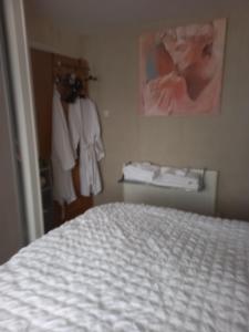 1 dormitorio con cama blanca y ropa en The Boat House BED ONLY NO BREAKFAST, en Aultbea