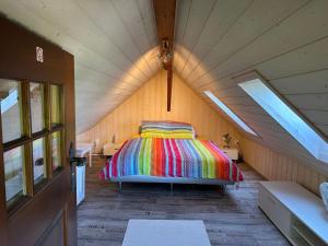een slaapkamer met een kleurrijk bed op een zolder bij Hadassa Apartment Mutzli in Steffisburg