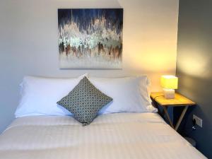 a bedroom with a bed with a painting on the wall at Donegal Town House in Donegal