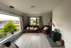 a living room with two leather chairs and a large window at Donegal Town House in Donegal