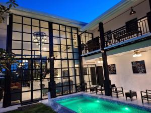 uma casa com piscina em frente a um edifício em The Courtyard Chiangrai em Chiang Rai