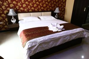 a bedroom with a large bed with a white flower on it at The Pattaya Sports Hub in Pattaya Central
