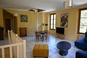 ein Wohnzimmer mit einem blauen Sofa und einem Tisch in der Unterkunft La Villa du Papetier in Boussières
