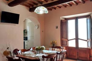 comedor con mesa con sillas y TV en La casa dei nonni, en Lucca