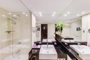 uma casa de banho com 2 lavatórios e um chuveiro em Cinnamon Lakeside em Colombo