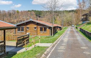 a road next to a log cabin with a car on it at Werrapark Resort Ferienhäuser Am Sommerberg in Masserberg