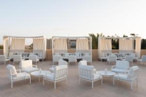 Almazino, Almaza Bay في ماجد أبو زيد: مجموعة من الكراسي البيضاء والطاولات على الفناء