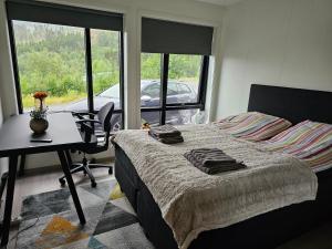 a bedroom with a bed and a desk and a window at Panorama wiev in Stranda