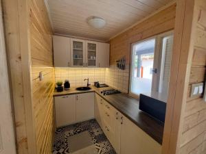 una pequeña cocina con fregadero y ventana en Zegzug Noszvaj, en Noszvaj