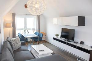 uma sala de estar com um sofá e uma mesa em ST4-12 - Ferienwohnung Komfort em Dorum Neufeld