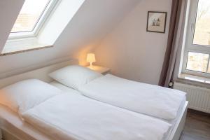 duas camas num quarto com duas janelas em ST4-12 - Ferienwohnung Komfort em Dorum Neufeld