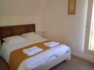 a bedroom with a bed with two towels on it at Cottage spacieux Domaine de la Bretesche in Missillac +13 photos