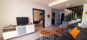 - un salon avec un canapé et une télévision dans l'établissement Villa Suculenta, à Playa Blanca