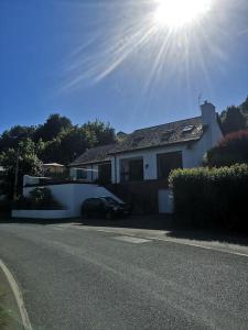 a white house with the sun in the sky at Riverside Retreat in Llandysul