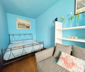 een blauwe kamer met een bed en een bank bij Charlotte Deluxe Apartment 2 in Trieste