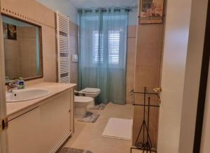 een badkamer met een wastafel, een toilet en een douche bij Charlotte Deluxe Apartment 2 in Trieste