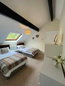 a attic bedroom with two beds and a window at Riverside Retreat in Llandysul