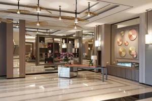 a lobby with a table in a building at Pinky Rose @Anderson Apartment in Surabaya