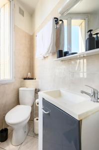 Baño blanco con aseo y lavamanos en Cosy T2 à 5 minutes de Metro 12-Proche Paris-Stade de France, en Aubervilliers